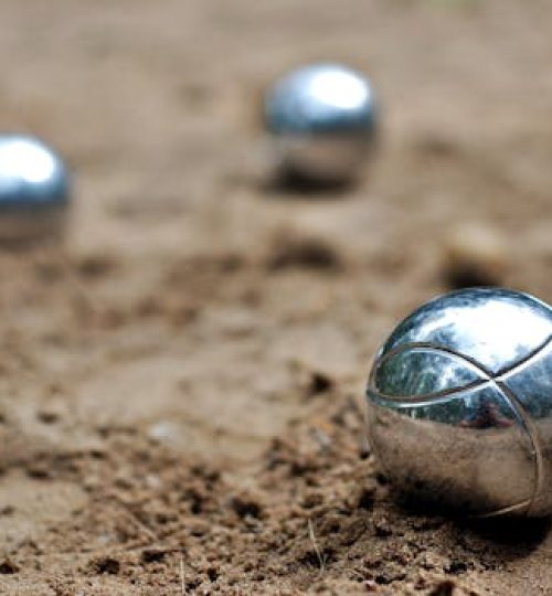 Close-up of shiny petanque balls on a sandy beach. Perfect for outdoor and leisure themes.